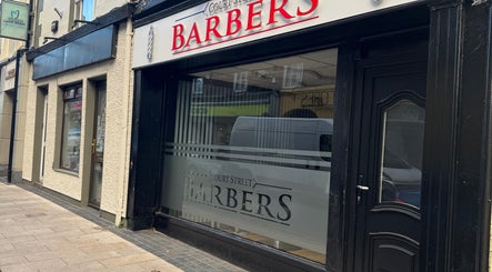 Court Street Barbers facade in Enniscorthy, County Wexford, IE featuring a stylish black doorway.
