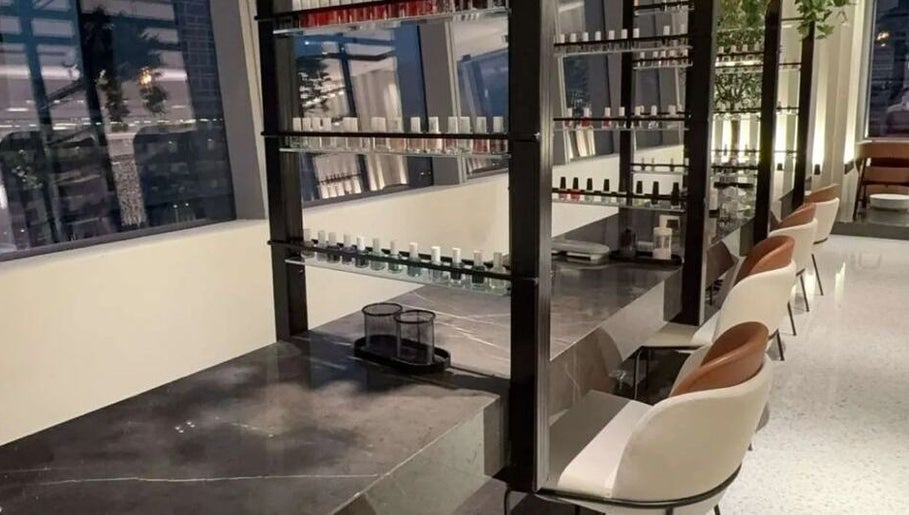 Nail Station interior in Doha, Doha Municipality, QA, showcasing elegant nail polish displays and seating.