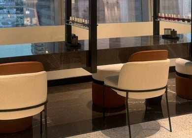 Elegant nail lounge at Nail Station, Doha, Doha Municipality, QA, featuring modern seating with city views.