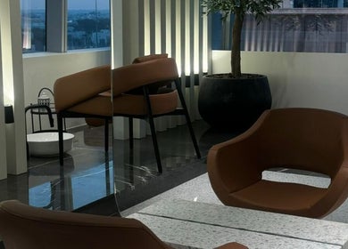 Elegant seating area at Nail Station, Doha, Doha Municipality, QA, featuring modern decor and city views.
