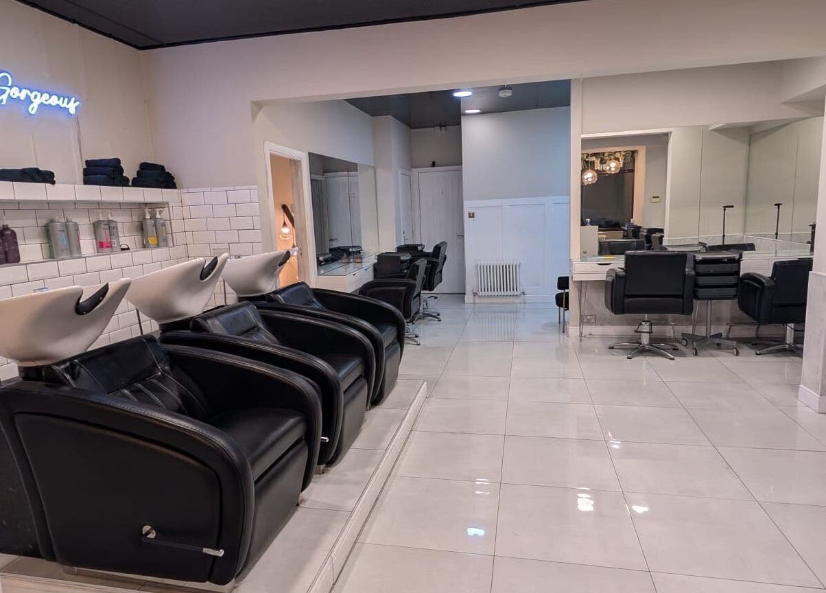 Modern salon interior at Hair by Ava, Leeds, England, GB, showcasing sleek styling stations and wash basins.