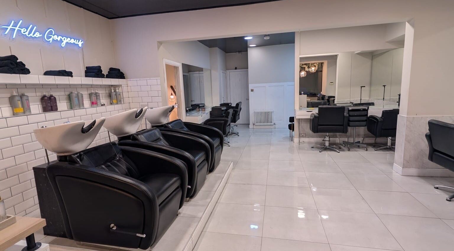 Modern salon interior at Hair by Ava, Leeds, England, GB, showcasing sleek styling stations and wash basins.