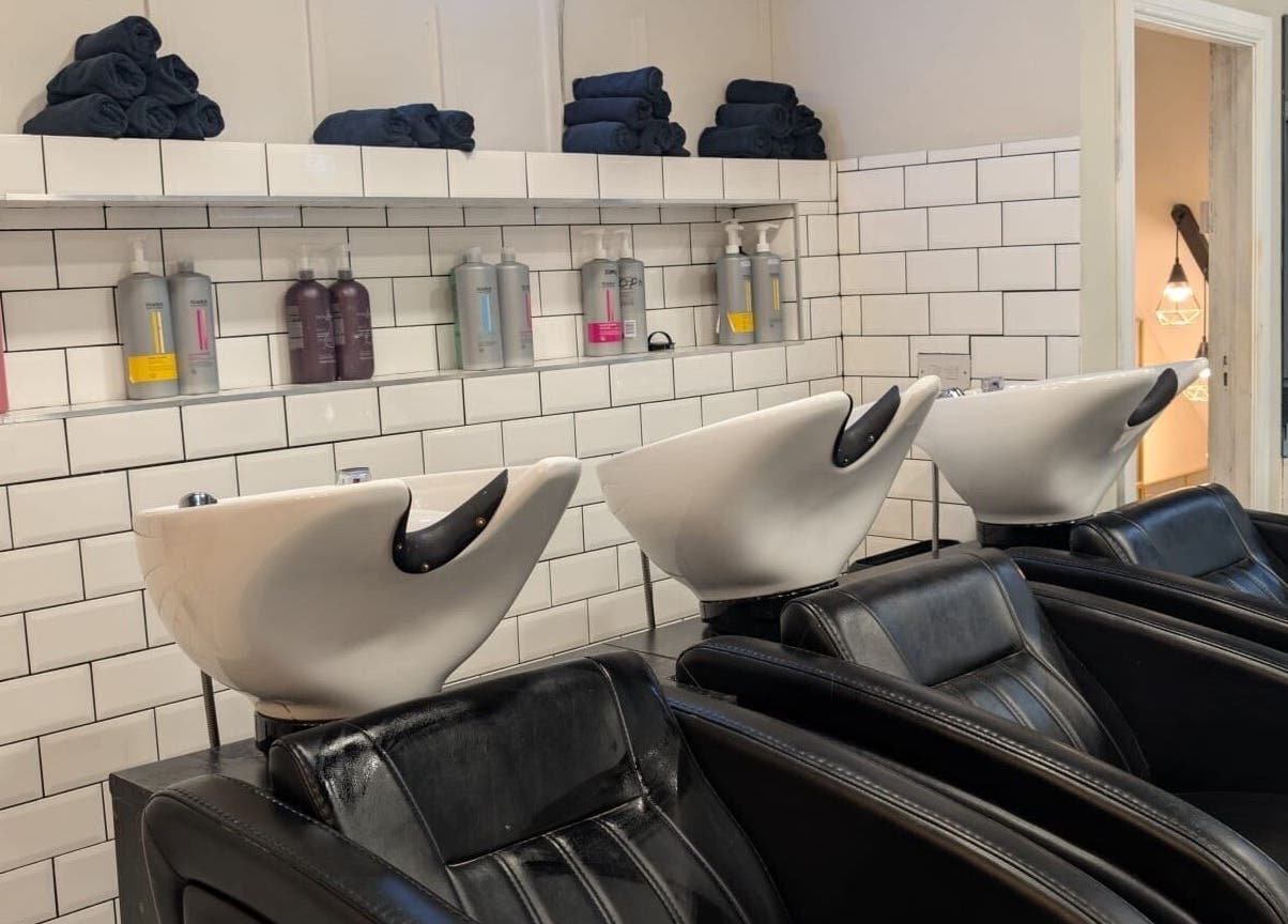 Modern wash stations at Hair by Ava, Leeds, England. Stylish seating and premium products on display.