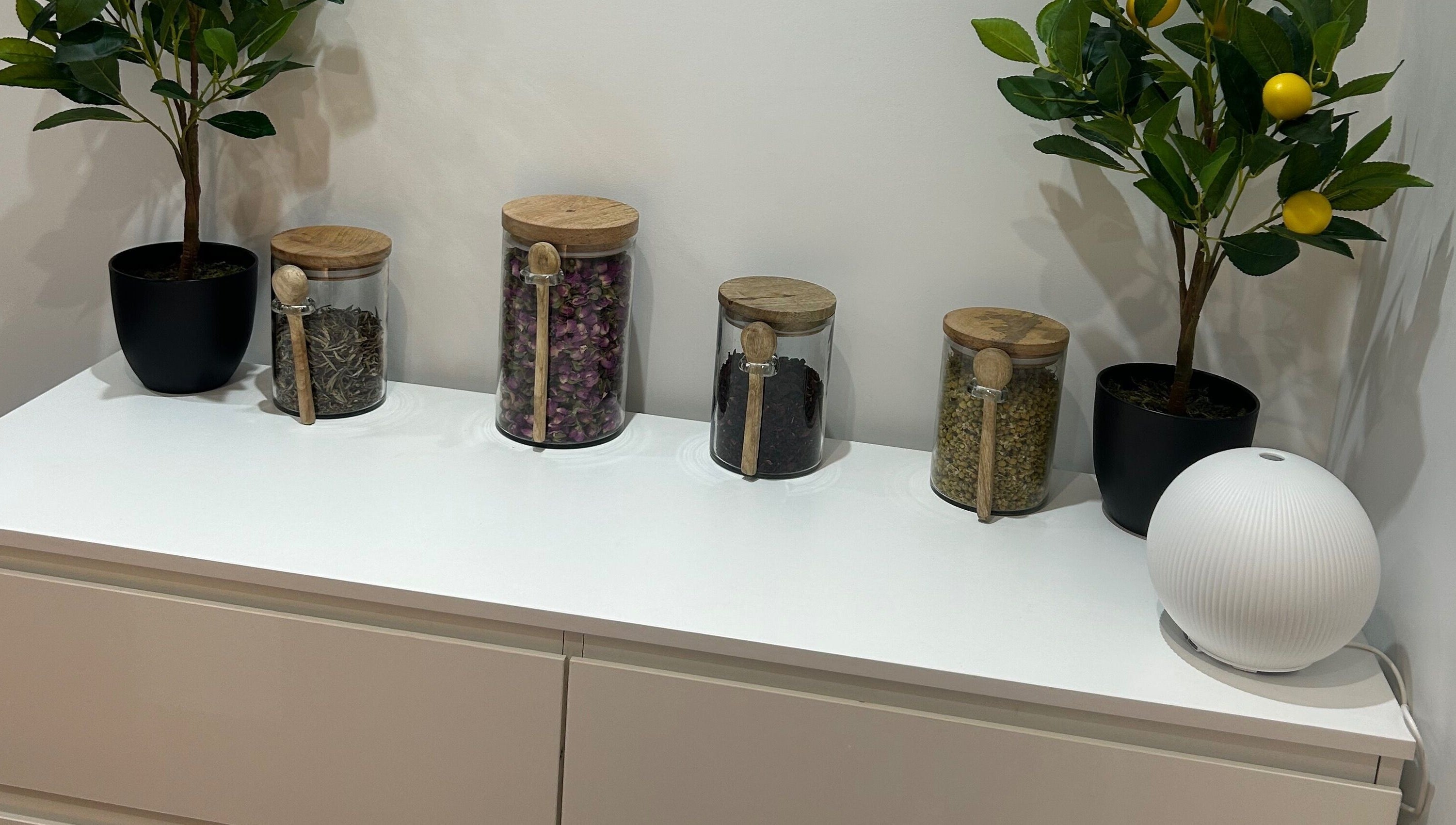 Glass jars with herbs and plants on a white shelf at Sanctum By Gemma, Beacon Hill, England, GB.