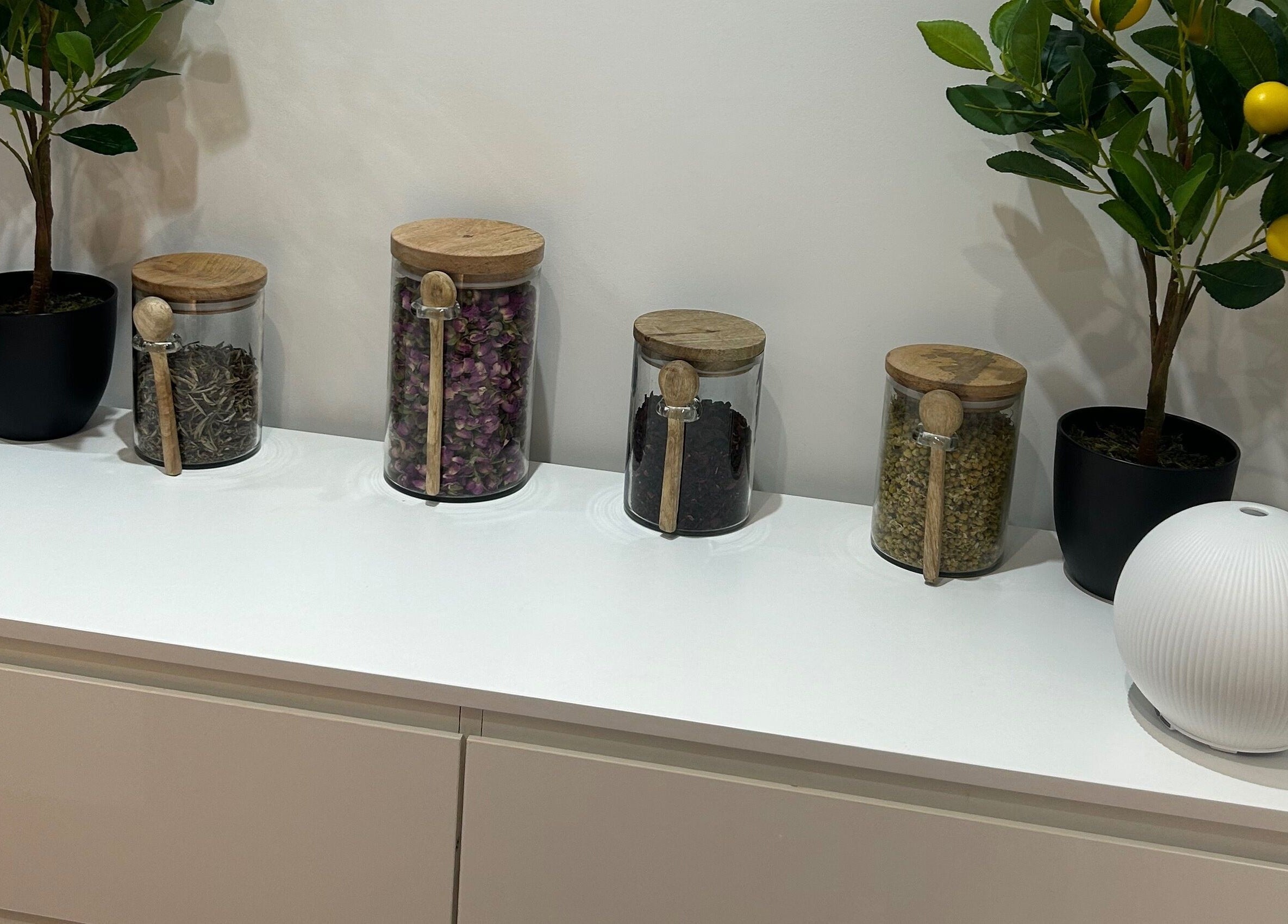 Glass jars with herbs and plants on a white shelf at Sanctum By Gemma, Beacon Hill, England, GB.