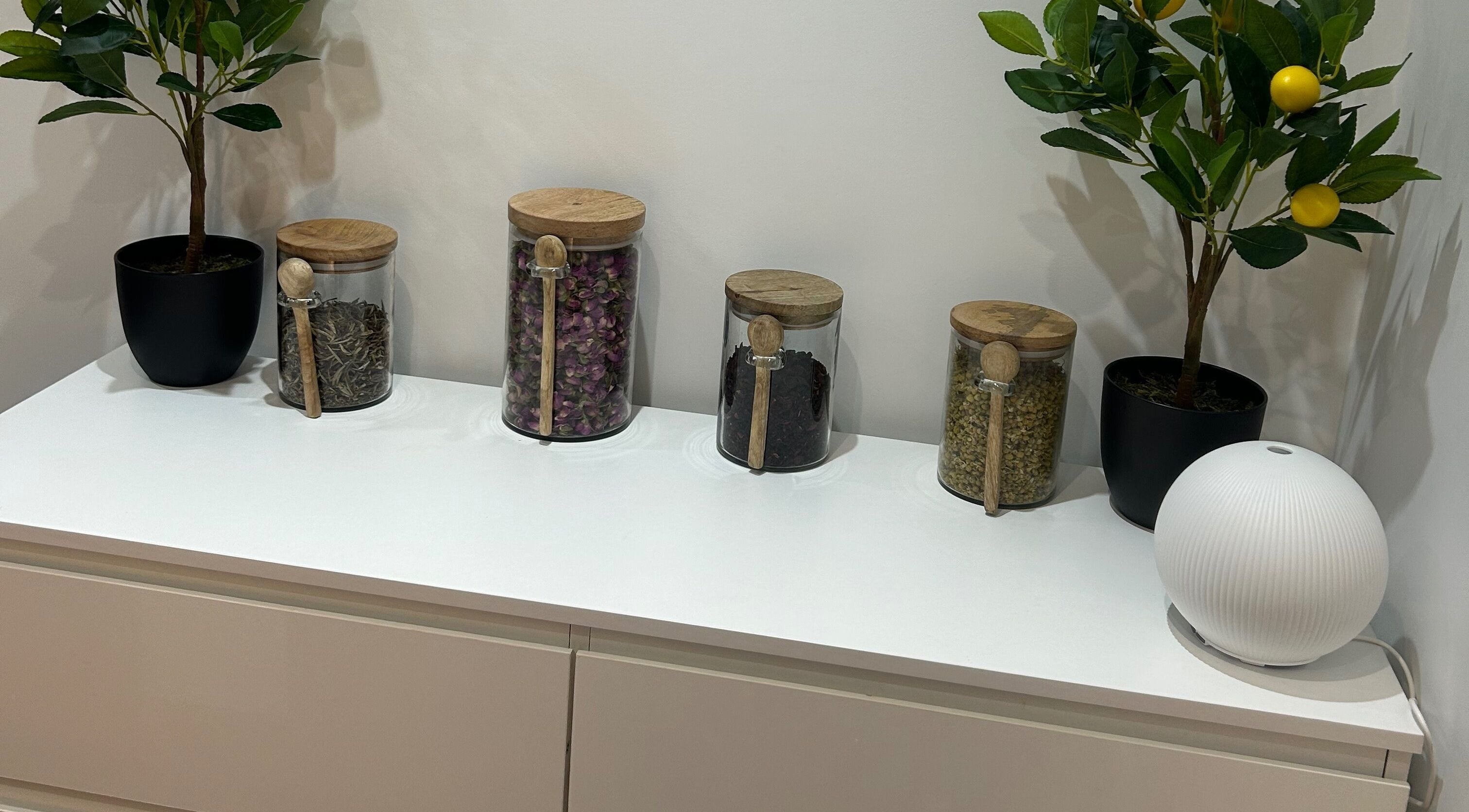 Glass jars with herbs and plants on a white shelf at Sanctum By Gemma, Beacon Hill, England, GB.