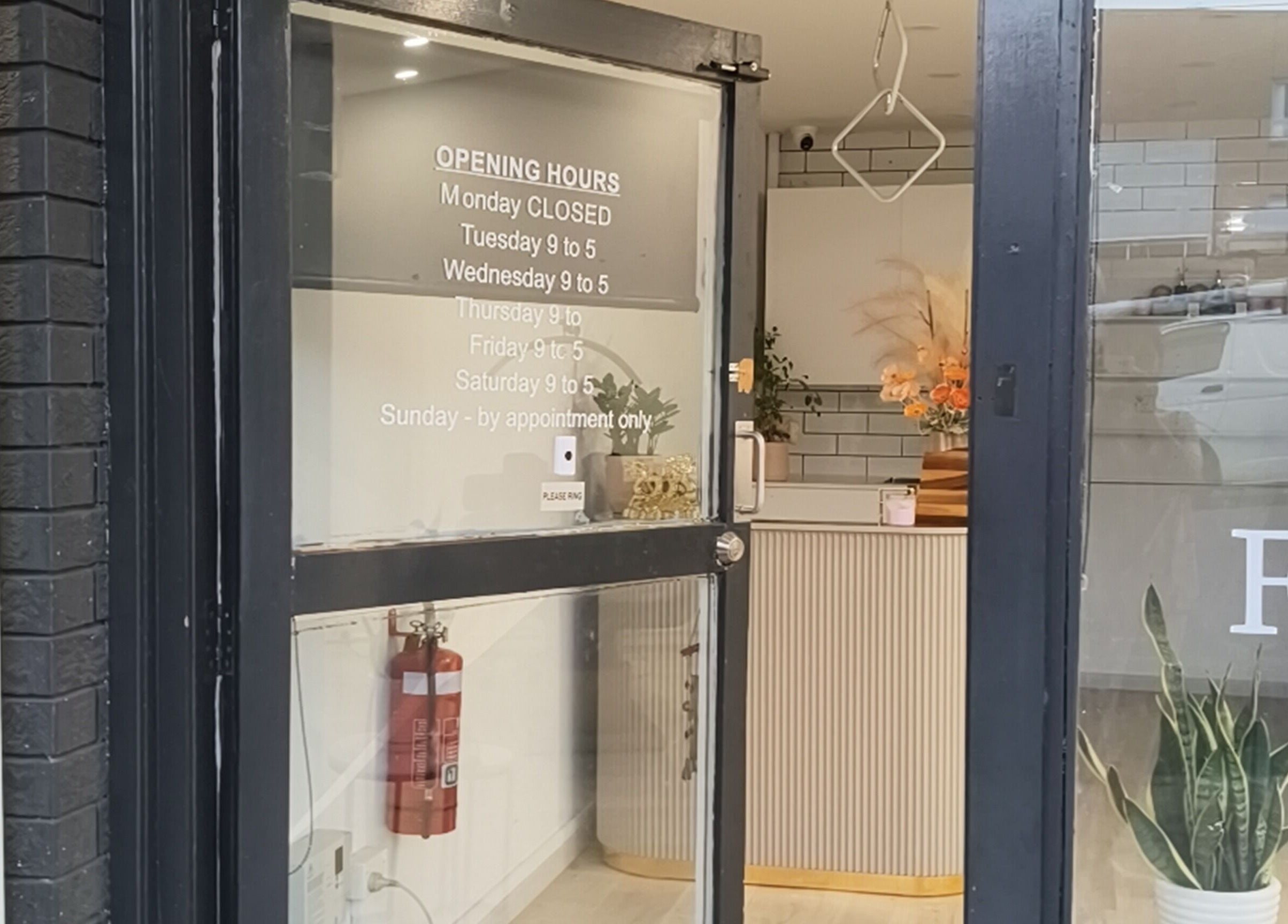 Front entrance of Zenith Spa, Regents Park, New South Wales, AU with welcoming decor and opening hours displayed.