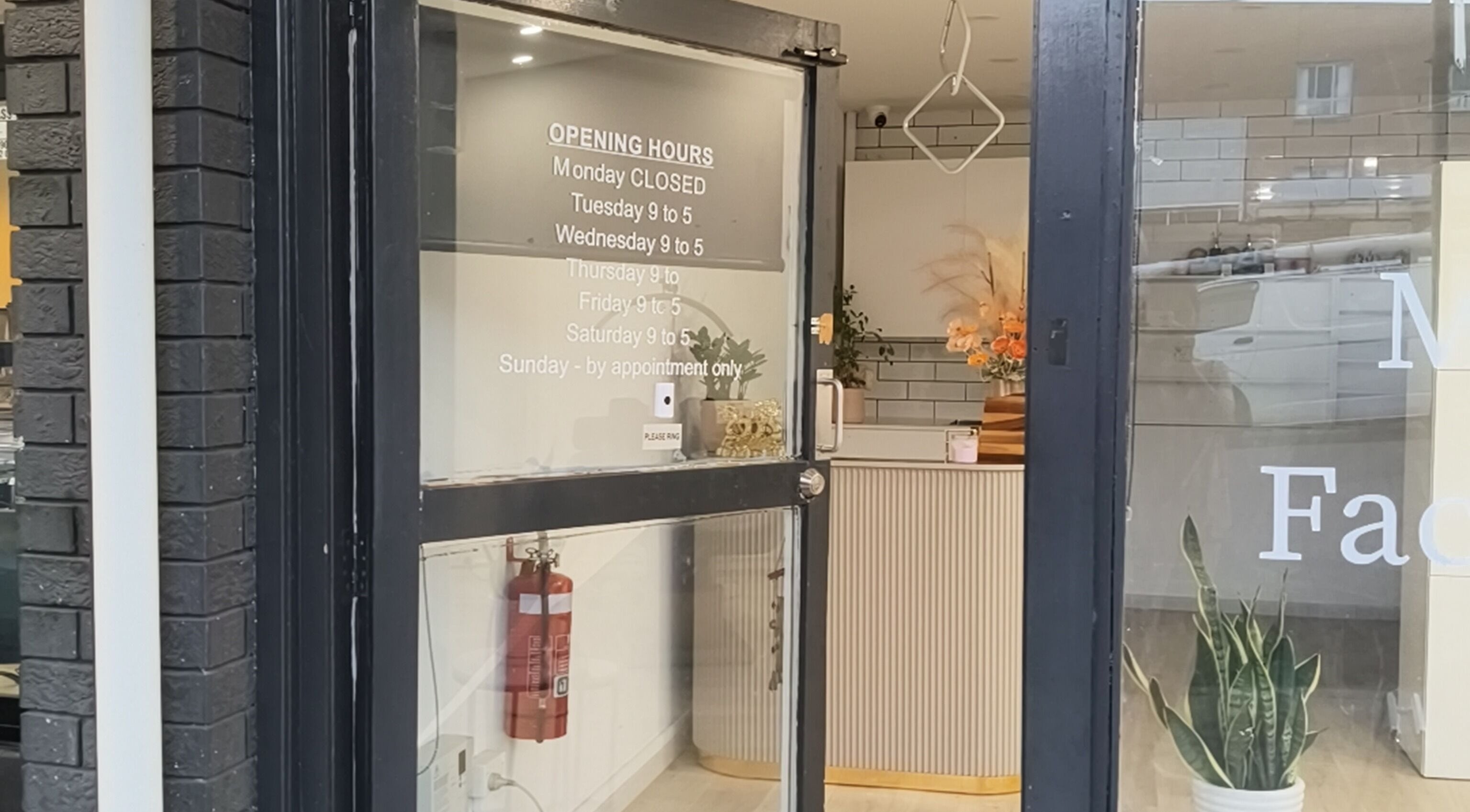 Front entrance of Zenith Spa, Regents Park, New South Wales, AU with welcoming decor and opening hours displayed.