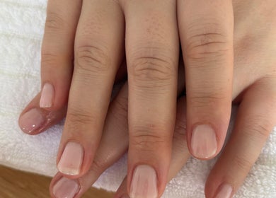 Freshly manicured hands at Petal&polish, Jimboomba, Queensland, AU. Soft pink nails on white towel.