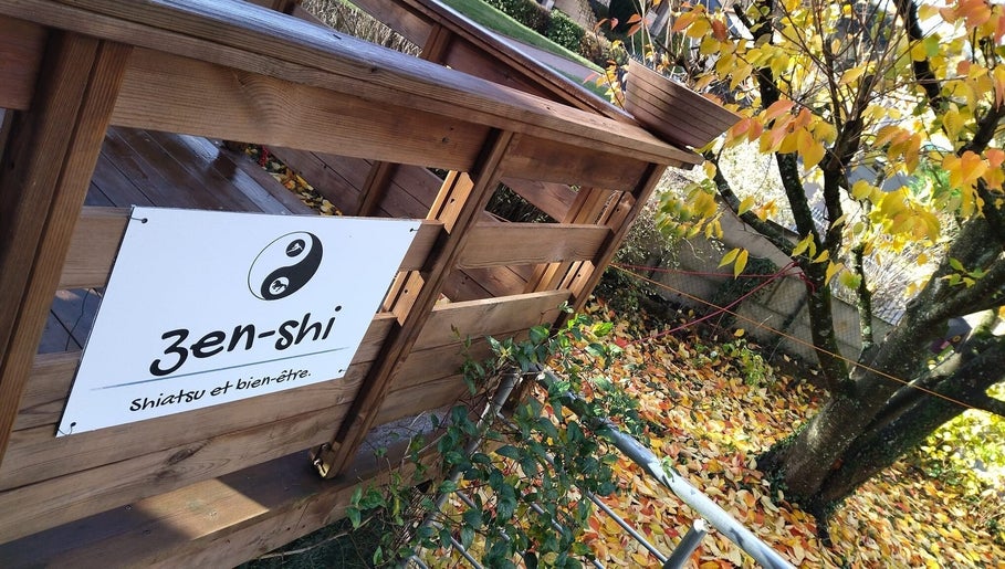Entrée en bois du Zen-Shi à Hayange, Grand Est, FR, entourée de feuilles d'automne.