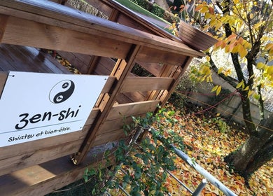Entrée en bois du Zen-Shi à Hayange, Grand Est, FR, entourée de feuilles d'automne.