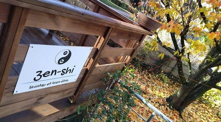 Entrée en bois du Zen-Shi à Hayange, Grand Est, FR, entourée de feuilles d'automne.