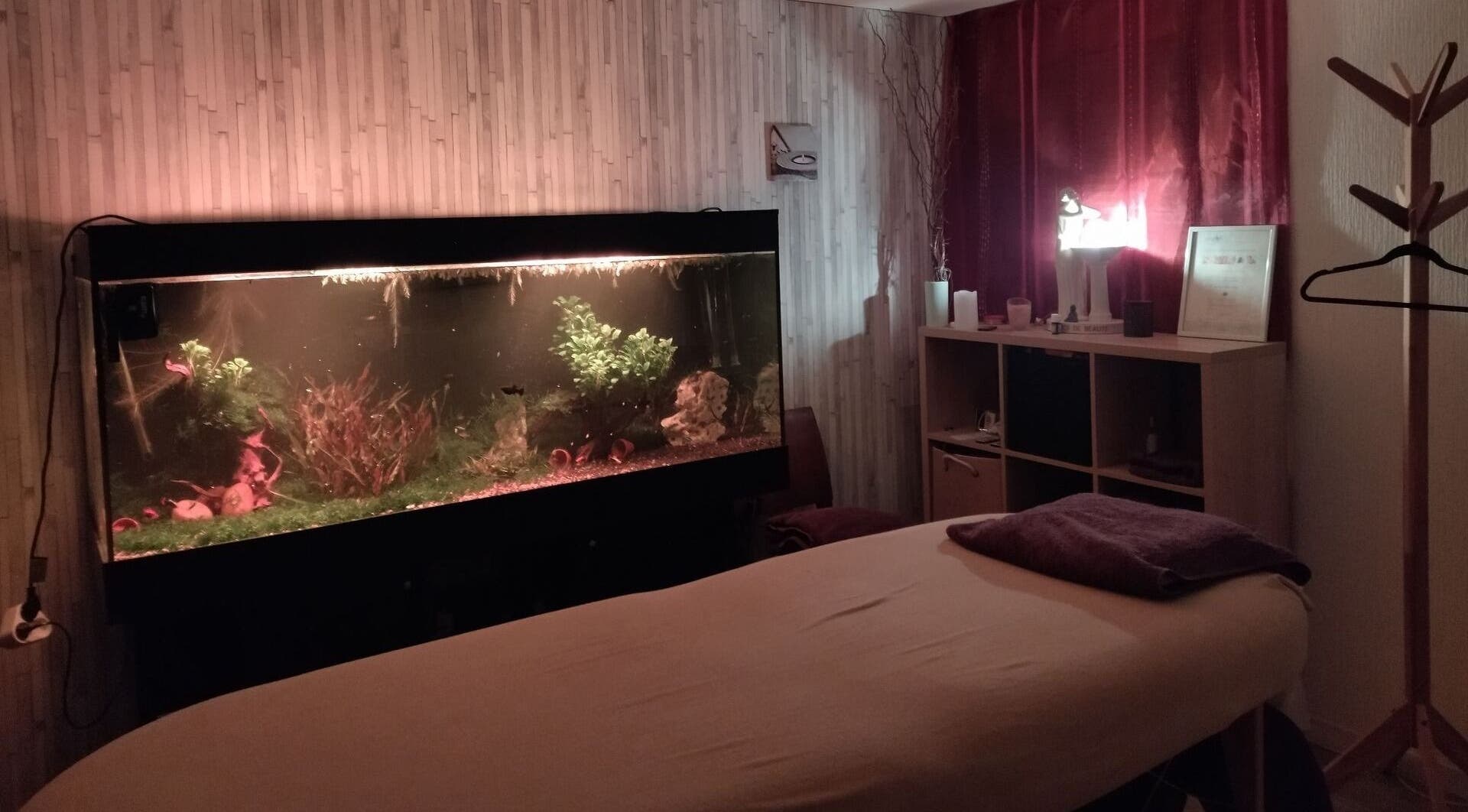 Salle de massage relaxante avec aquarium éclairé chez Zen-Shi, Hayange, Grand Est, FR.