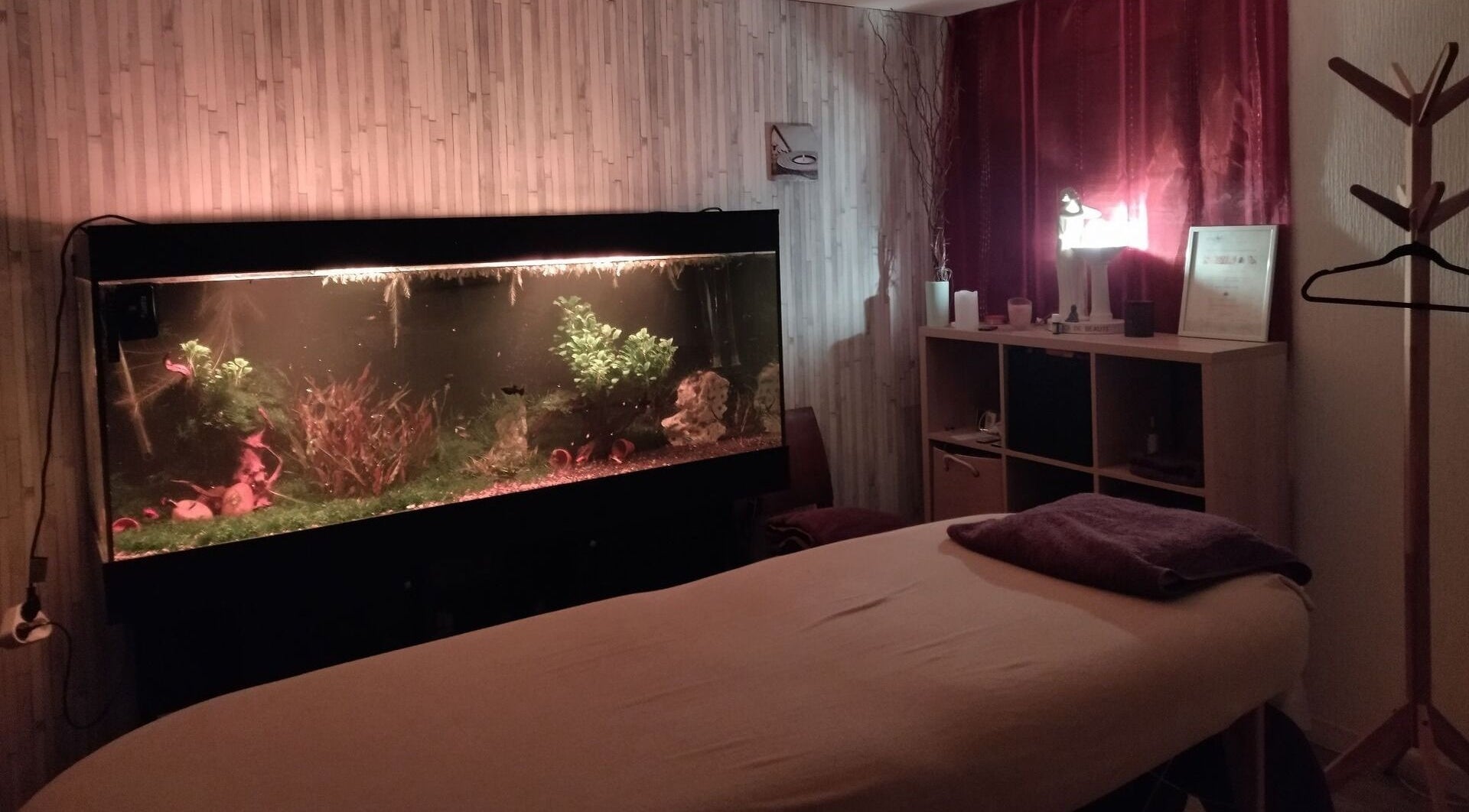 Salle de massage relaxante avec aquarium éclairé chez Zen-Shi, Hayange, Grand Est, FR.