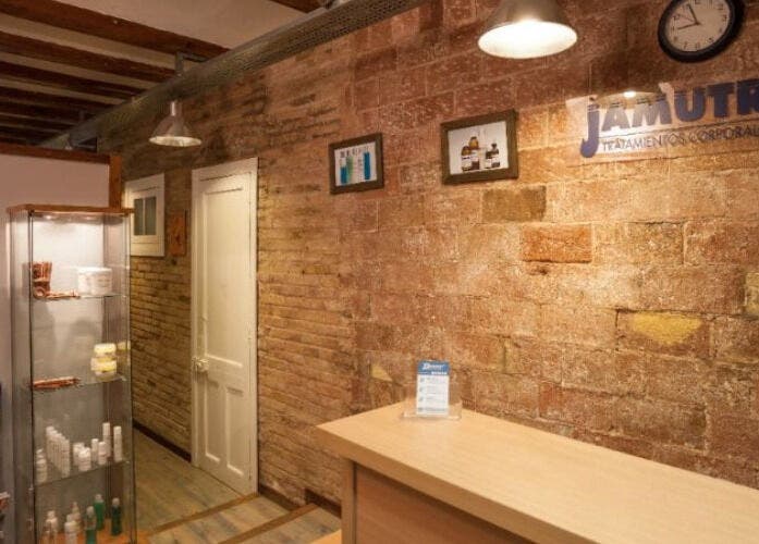 Recepción cálida de Benestar Sarrià en Barcelona, Catalunya, ES, con paredes de ladrillo y estanterías de productos.