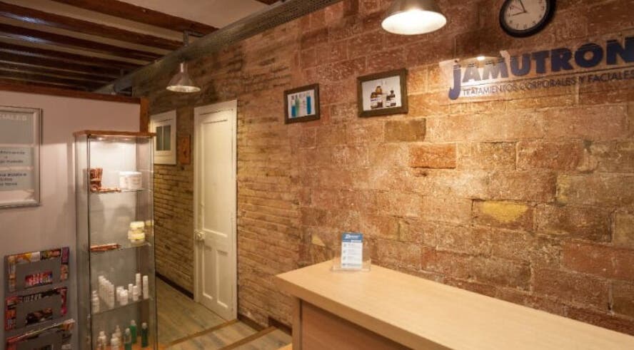 Recepción cálida de Benestar Sarrià en Barcelona, Catalunya, ES, con paredes de ladrillo y estanterías de productos.