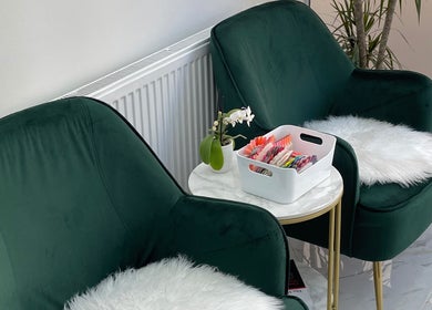 Elegant waiting area at MK Nails and Spa Fulham Ltd, London, England, GB, featuring plush green chairs and nail samples.