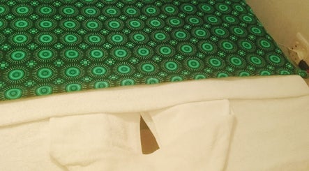 Relaxing massage table with green cover at Jojoesthaispa, Edenvale, Gauteng, ZA, offering serene wellness vibes.