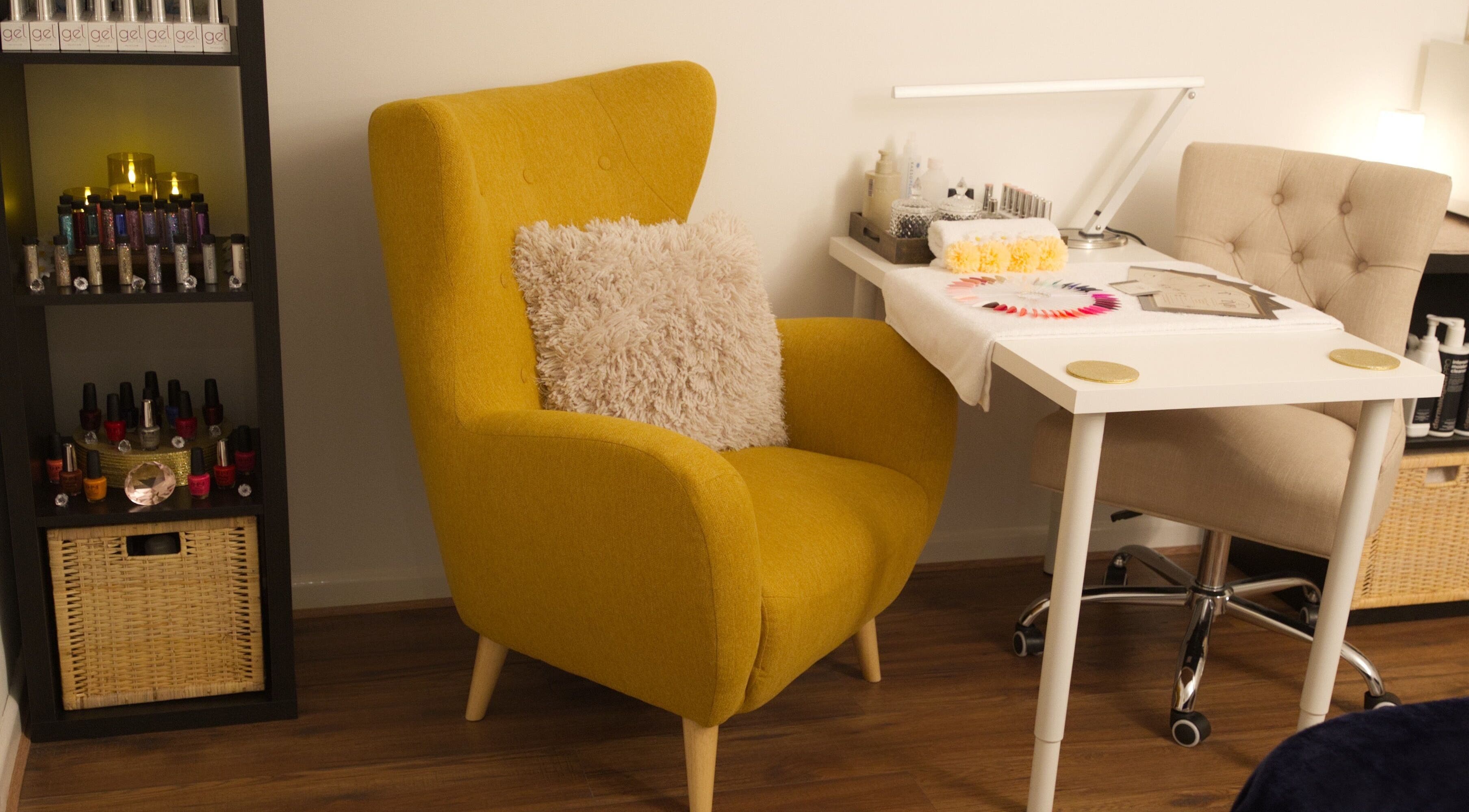 Inviting nail station at TMB Beauty, Brighton, GB with plush mustard chair and organized polish display.