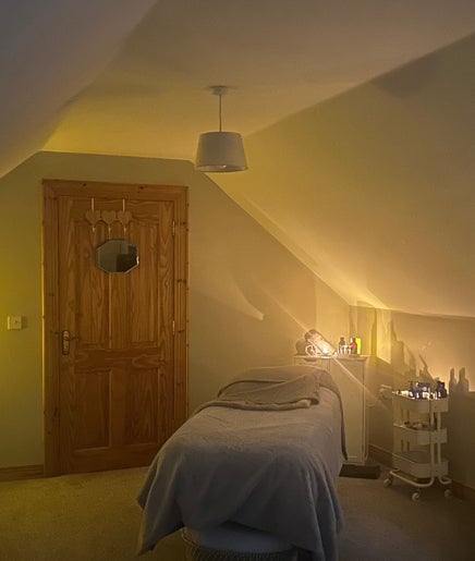 Cozy spa room at Swannlodge Beauty, Limavady, Northern Ireland, GB with ambient lighting and a massage table.