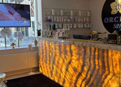 Welcoming interior of Orchid Spa, Rīga, LV, featuring a glowing reception desk and peaceful decor.