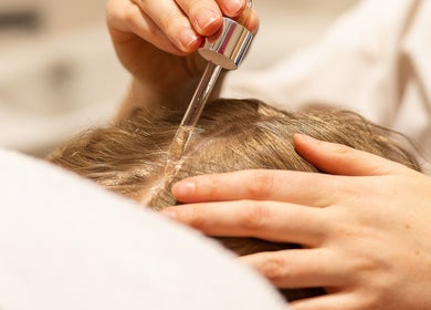 Application d'un sérum capillaire chez En Corps à Vitré, Bretagne, FR, pour des cheveux revitalisés.
