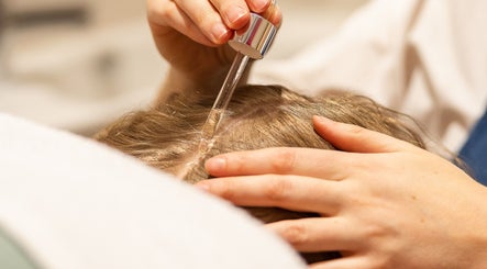 Application d'un sérum capillaire chez En Corps à Vitré, Bretagne, FR, pour des cheveux revitalisés.