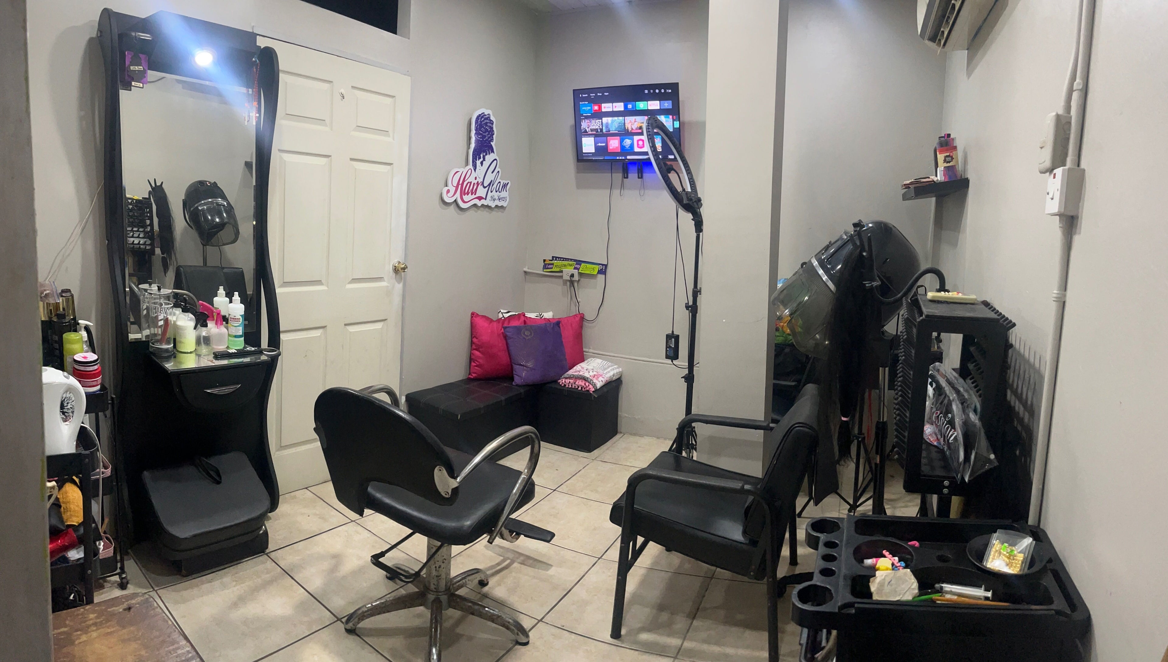 Elegant interior of HAIRGLAMBYKEEMZ in Sangre Grande showcasing salon tools and cozy seating.