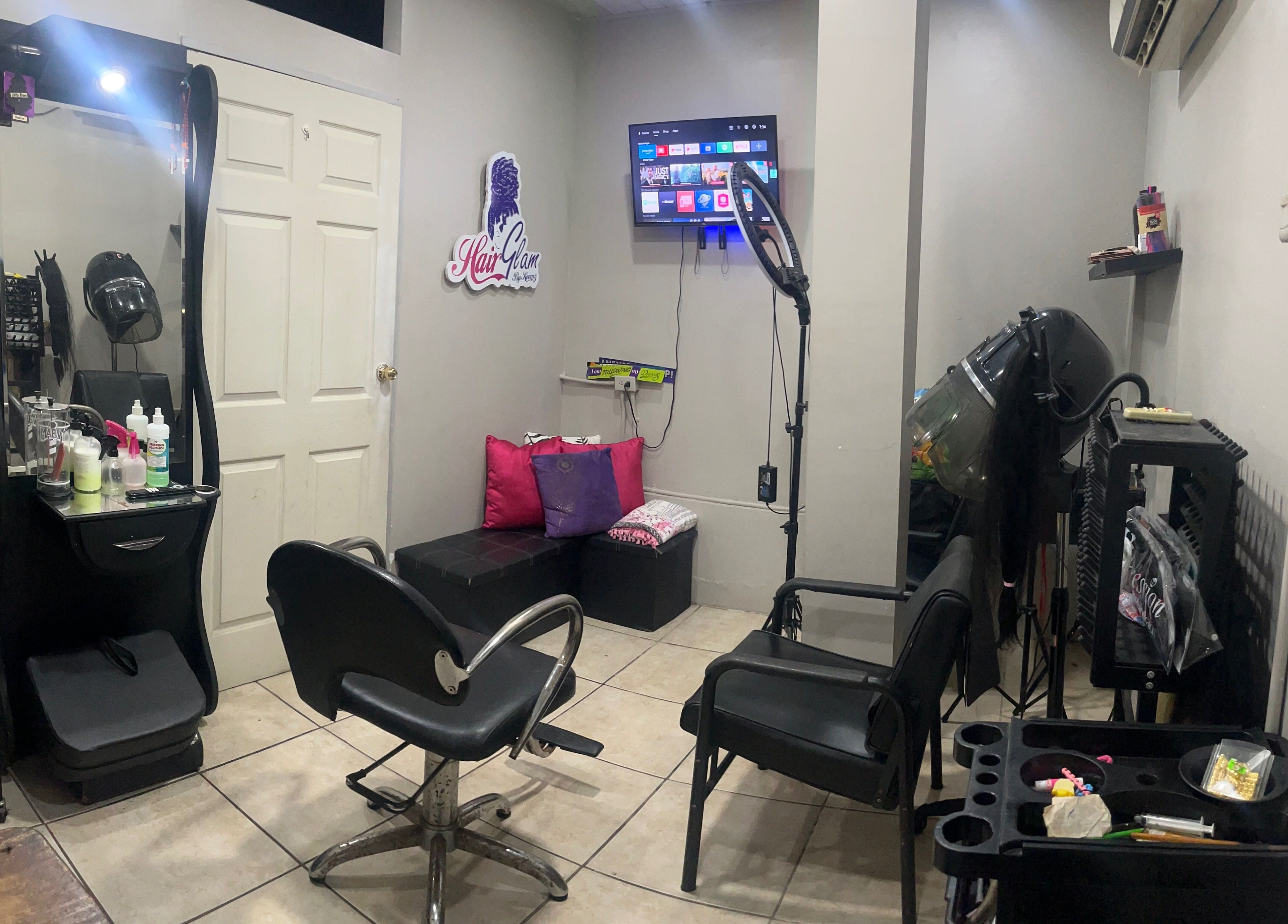 Elegant interior of HAIRGLAMBYKEEMZ in Sangre Grande showcasing salon tools and cozy seating.