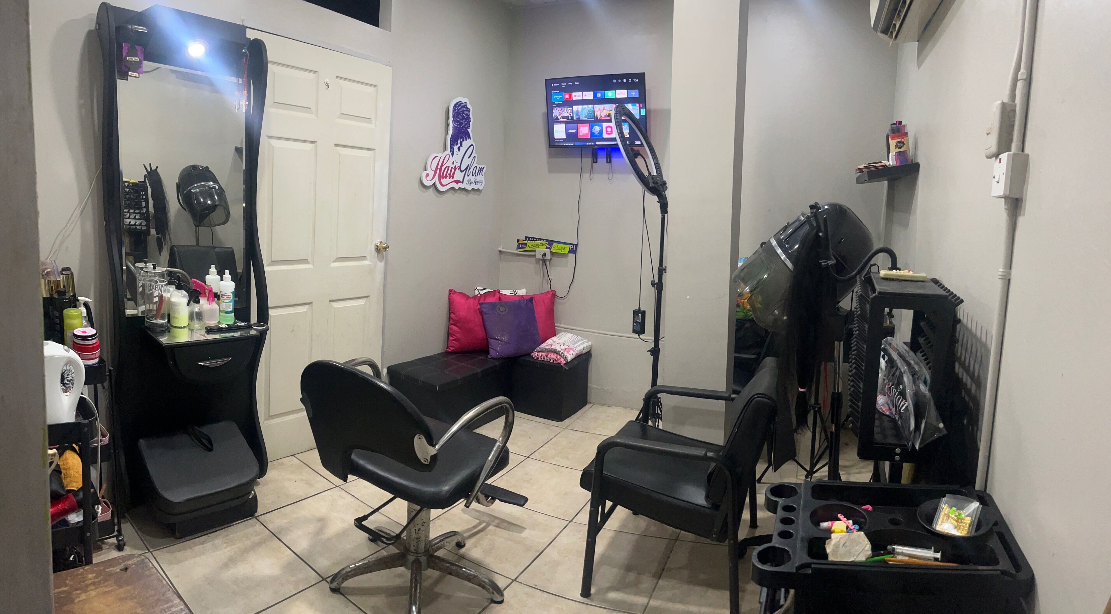 Elegant interior of HAIRGLAMBYKEEMZ in Sangre Grande showcasing salon tools and cozy seating.