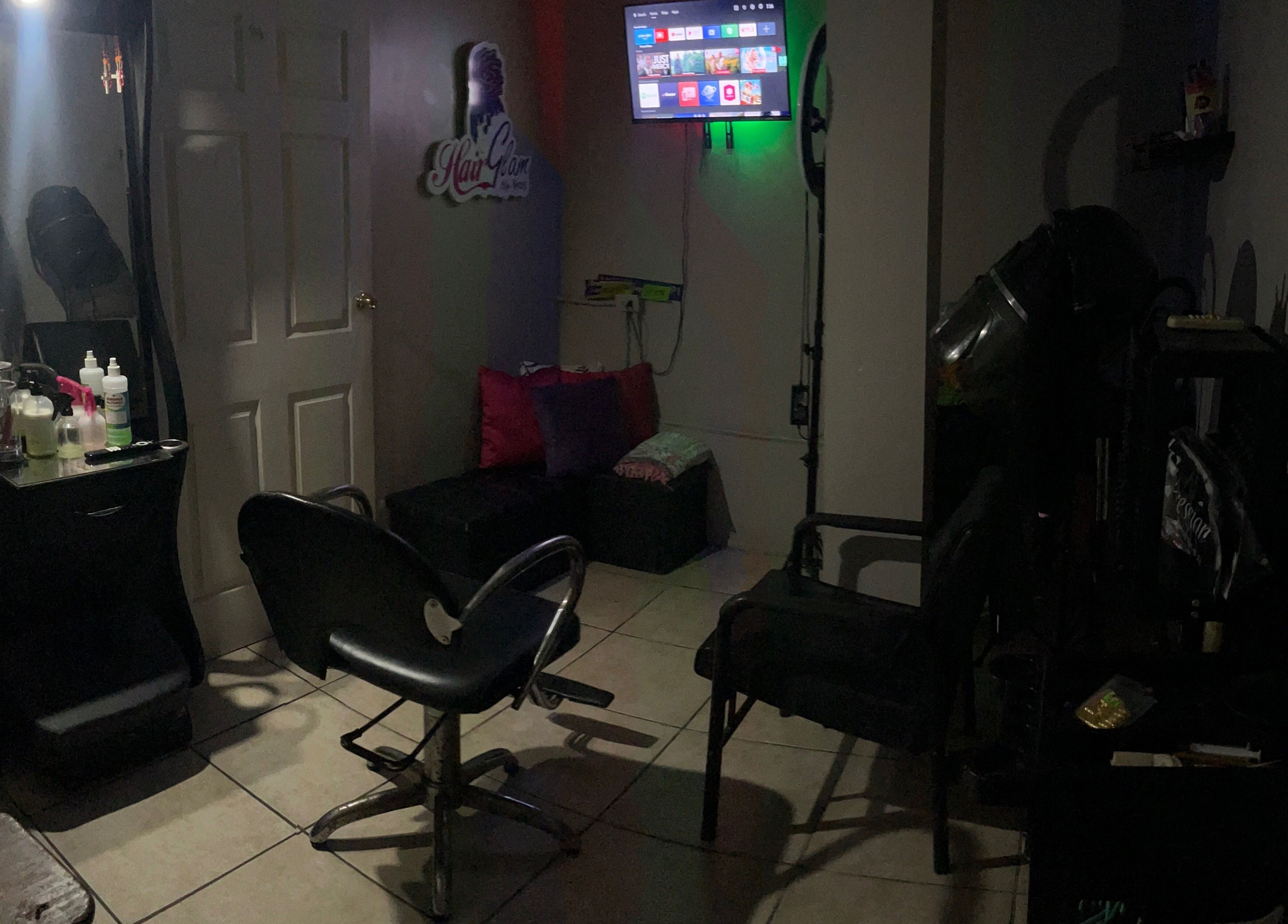 HAIRGLAMBYKEEMZ salon interior in Sangre Grande, cozy styling station with vibrant pillows and modern decor.