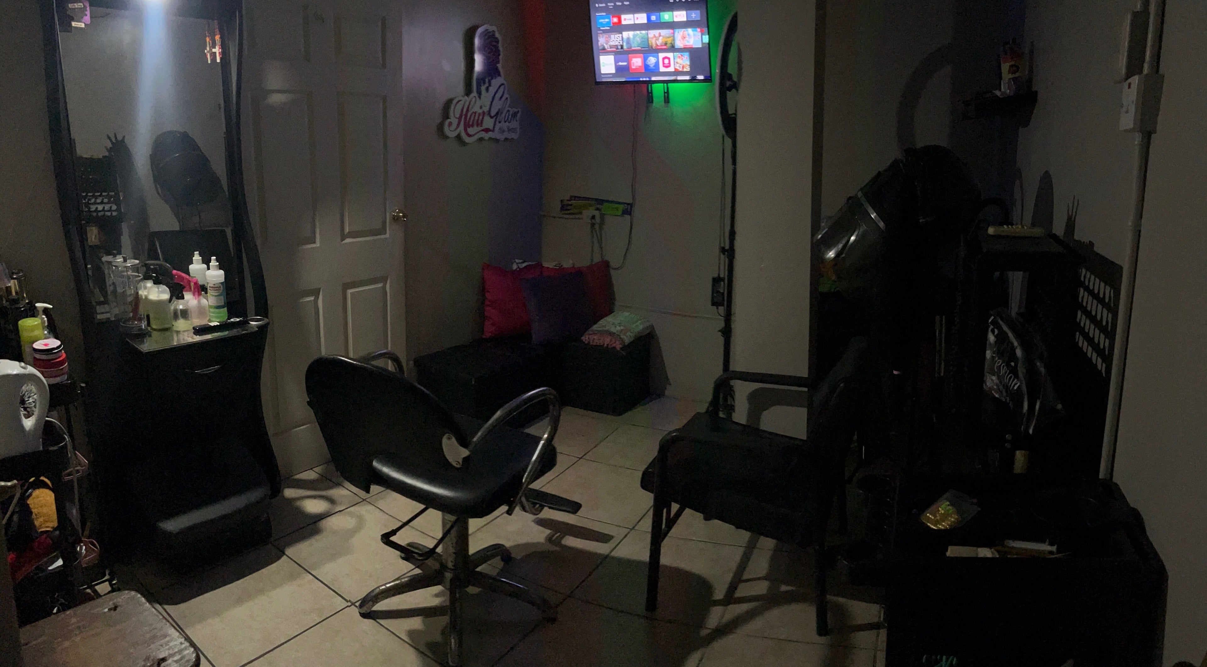 HAIRGLAMBYKEEMZ salon interior in Sangre Grande, cozy styling station with vibrant pillows and modern decor.