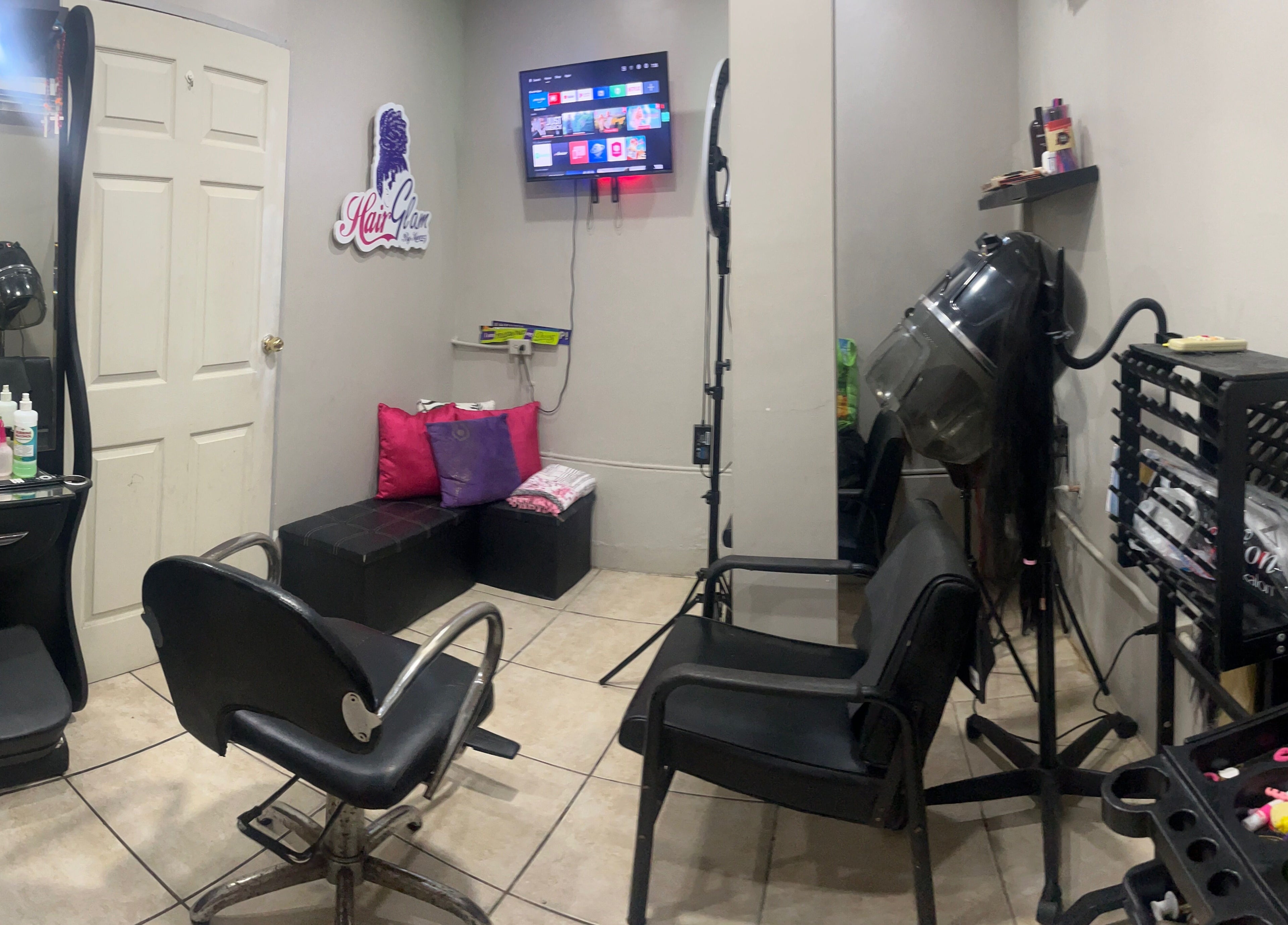 Modern salon interior at HAIRGLAMBYKEEMZ, Sangre Grande, featuring stylish chairs and vibrant decor.