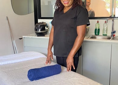 Massage therapist at Virgors beauty center, Cape Town, Western Cape, ZA, prepares treatment room.