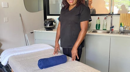 Massage therapist at Virgors beauty center, Cape Town, Western Cape, ZA, prepares treatment room.