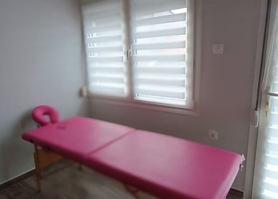 Ροζ κρεβάτι μασάζ στο The F.L.Y. Room, Γιάννουλη, GR, προσφέροντας χαλαρωτική εμπειρία ομορφιάς.