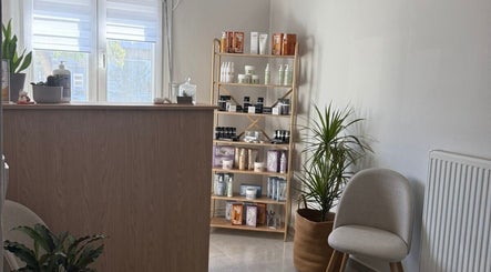 Κομψός χώρος υποδοχής στο The F.L.Y. Room στη Γιάννουλη, GR, με προϊόντα ομορφιάς σε ράφι.