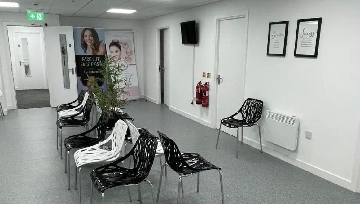Stylish waiting area at SW Massage in St Helens, England, GB featuring modern black and white chairs.