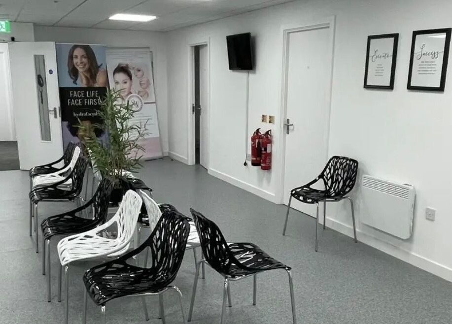 Stylish waiting area at SW Massage in St Helens, England, GB featuring modern black and white chairs.