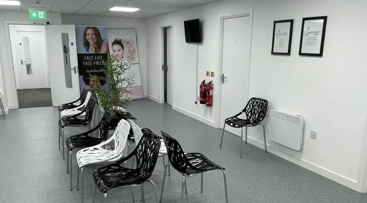 Stylish waiting area at SW Massage in St Helens, England, GB featuring modern black and white chairs.