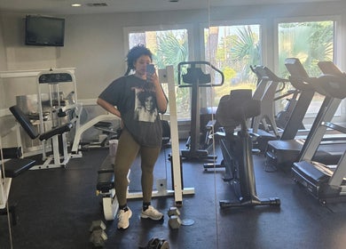 Modern fitness room at Sach Hair Braiding, Houston, TX, US with equipment and mirrored wall.