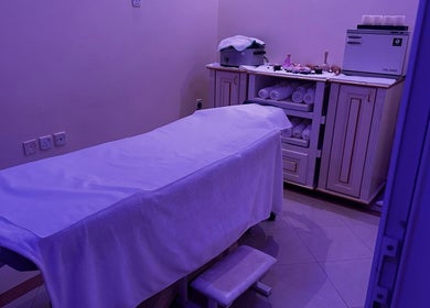 Serene treatment room at Ivari Beauty Centre, Ras Al-khaimah, with a massage bed and towels.