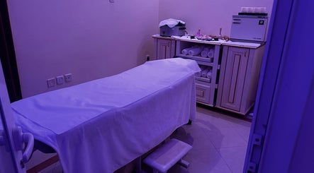 Serene treatment room at Ivari Beauty Centre, Ras Al-khaimah, with a massage bed and towels.