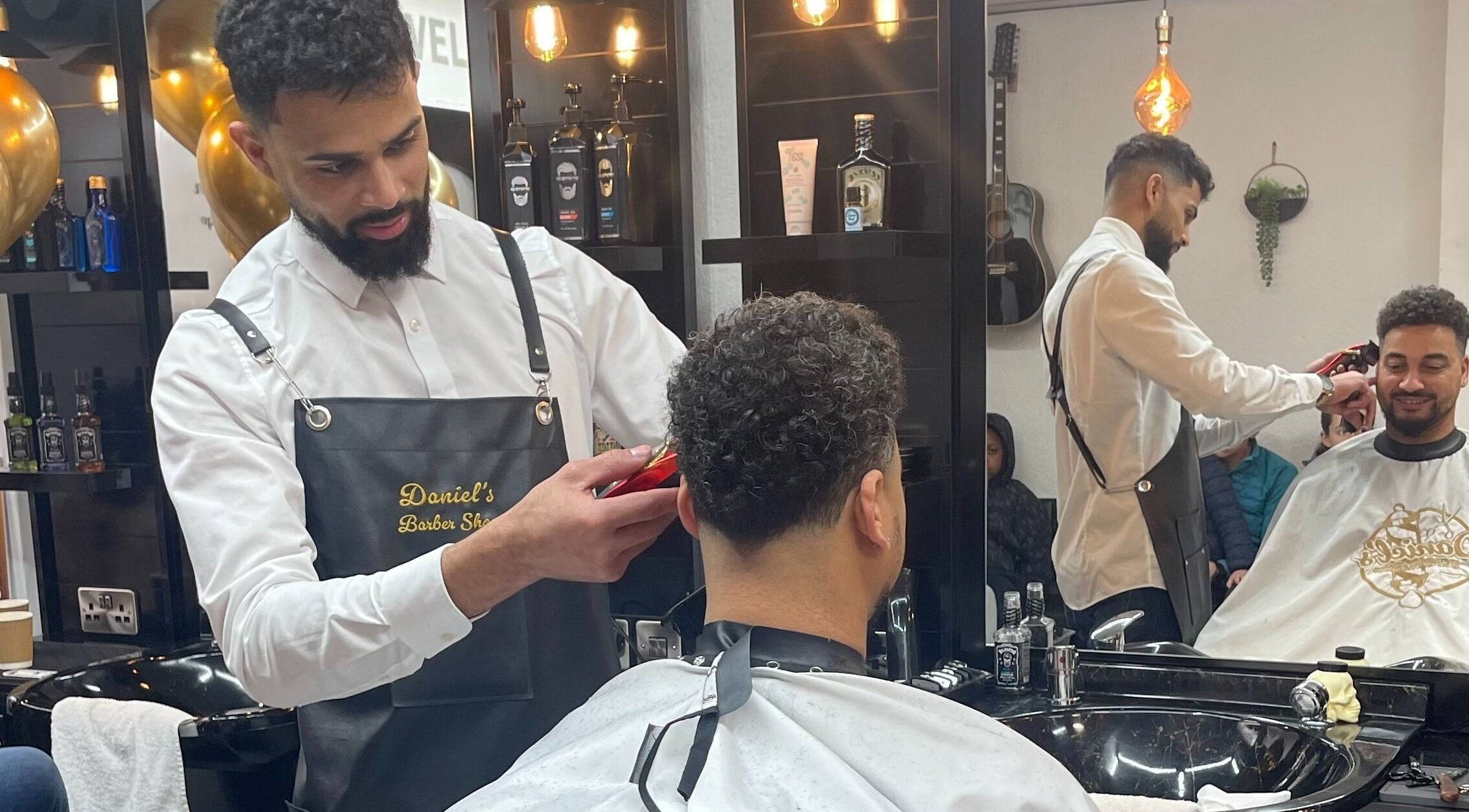 Barbeiro no Daniel's Barber Shop em Roscommon, IE, cortando cabelo de cliente curtido.