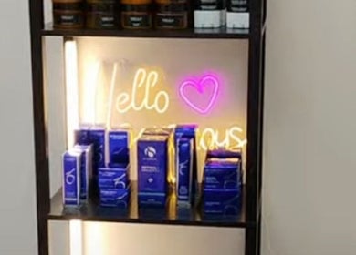 Beauty product display with 'Hello Gorgeous' neon at Soul Pretty Aesthetics, Gilbert, Arizona, US.