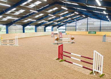 Indoor equestrian arena at Marwood Equestrian, Barnard Castle, England, GB with various jumps.