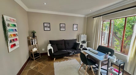 Nail lounge at Nude by Nicole, Kempton Park, Gauteng, ZA with plush seating and a vibrant polish display.