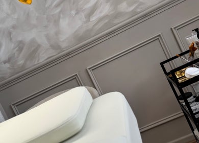 Treatment room at Skin Luse, Hazel Grove, England, GB, featuring a spa bed and product cart in elegant decor.