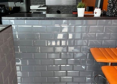 Stylish reception at Mind Over Matter Tattoo Studio, Hazel Grove, England, GB with modern decor and orange seating.