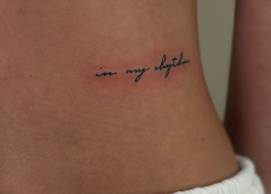Elegant script tattoo saying 'in my rhythm' at Inklet Studio, Dunmow, England, GB.